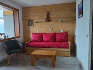A wooden interior with a sofa, a chair, and a table. - Studio - 4 guests, Mont Blanc view (La Plagne Montchavin Les Coches)