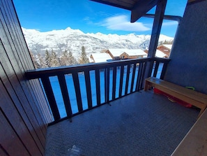 A balcony with a metal railing, a wooden bench, and a view of snow-covered mountains. - Studio - 4 guests, Mont Blanc view (La Plagne Montchavin Les Coches)