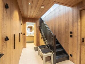 A wooden interior with a staircase, a bench, and a circular mirror. - Duplex apartment with spa - 3 bedrooms - Arc 1800 (Les Arcs 1800)