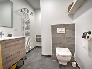 Ein modernes Badezimmer mit Toilette, Waschbecken und Handtuchhalter.