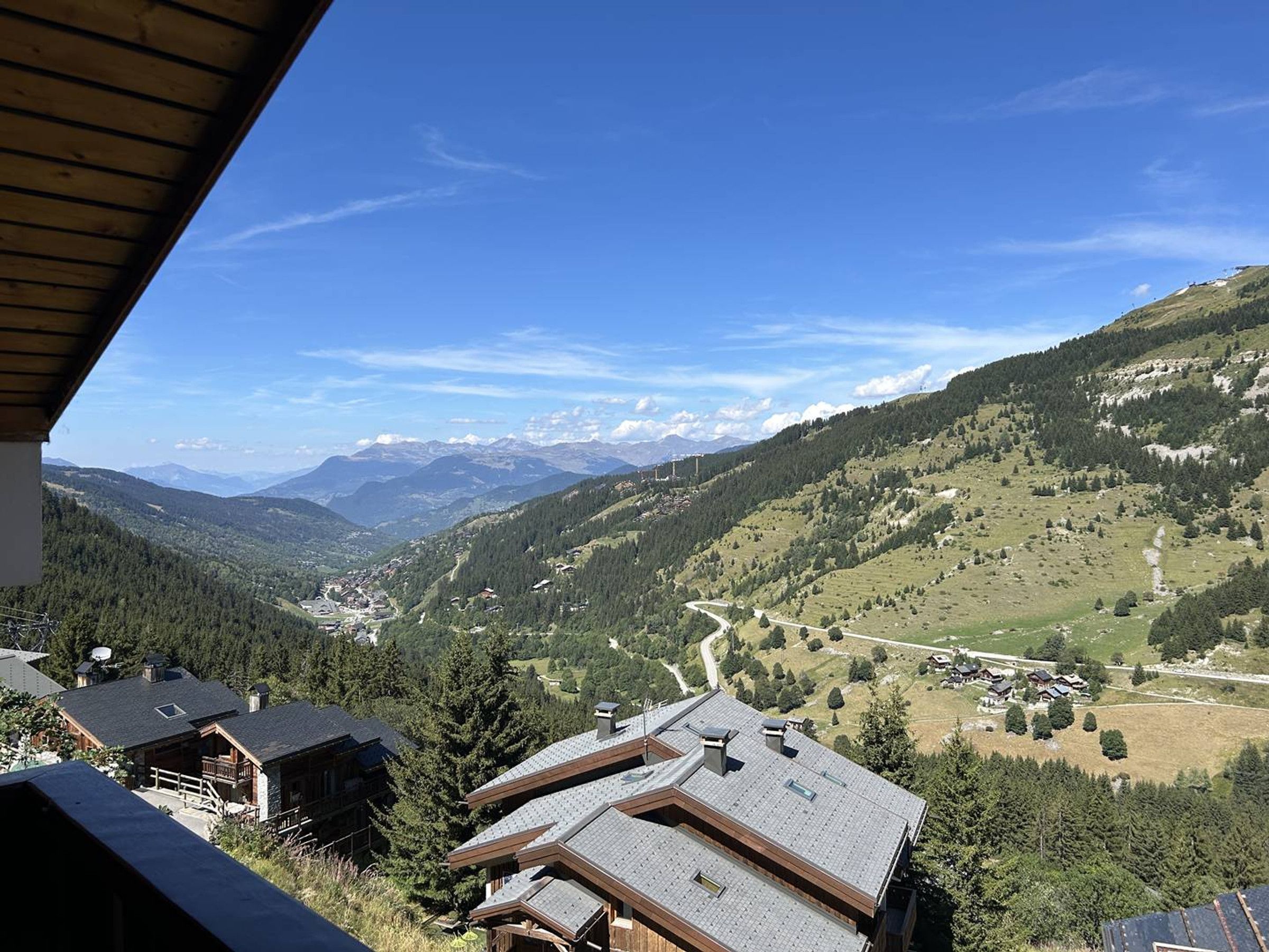 Une vue sur la montagne, avec un chalet en bois et un ciel dégagé.