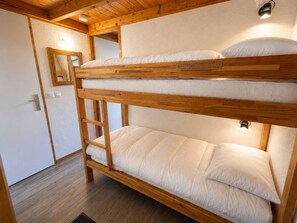 A bunk bed with a ladder, wooden beams, and a white mattress. - Quiet apartment near slopes - 4 guests (Les Allues)
