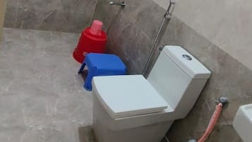 Un baño con ducha, inodoro y bidé.