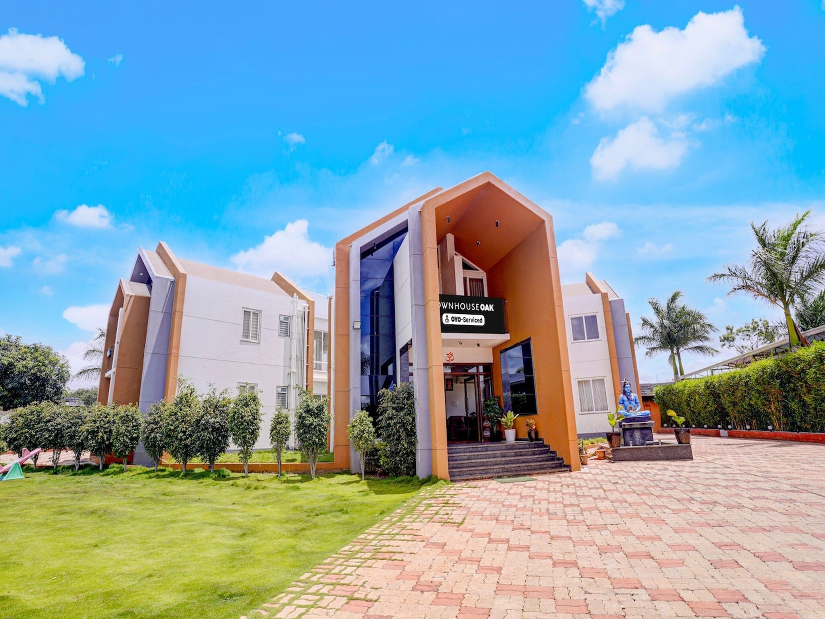 A modern building with a sign indicating it is serviced by OYO.