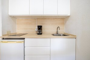 A compact kitchenette with a coffee maker, a sink, and a dishwasher. - GuestReady - Los Alisios Corralejo 39 (La Oliva)