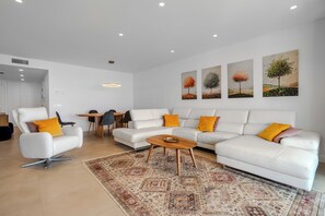 A modern living room with a white sofa set, a coffee table, and a patterned rug. - LME81B - Sea view terrace - indoor pool (Estepona)