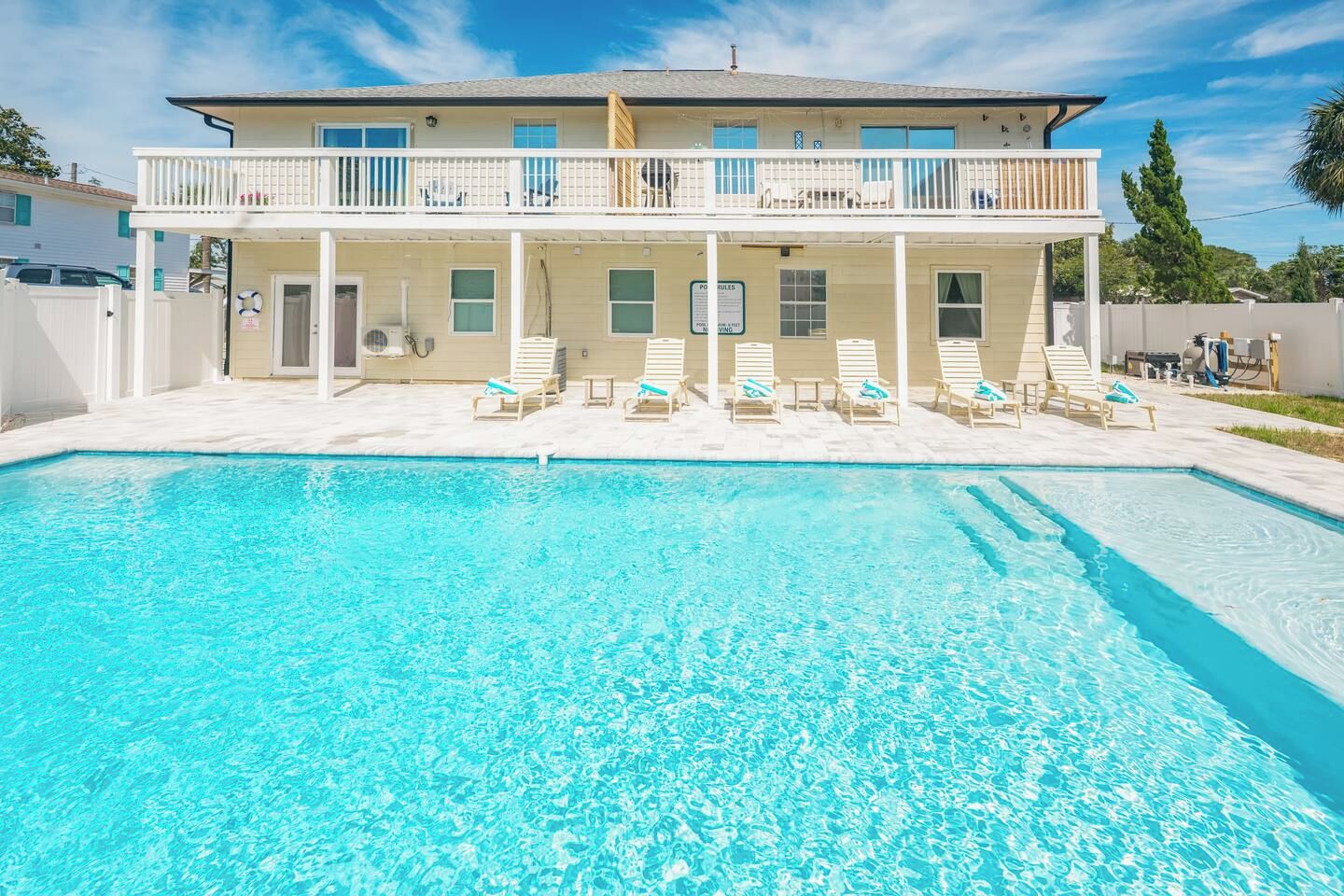 A two-story building with a swimming pool in front.