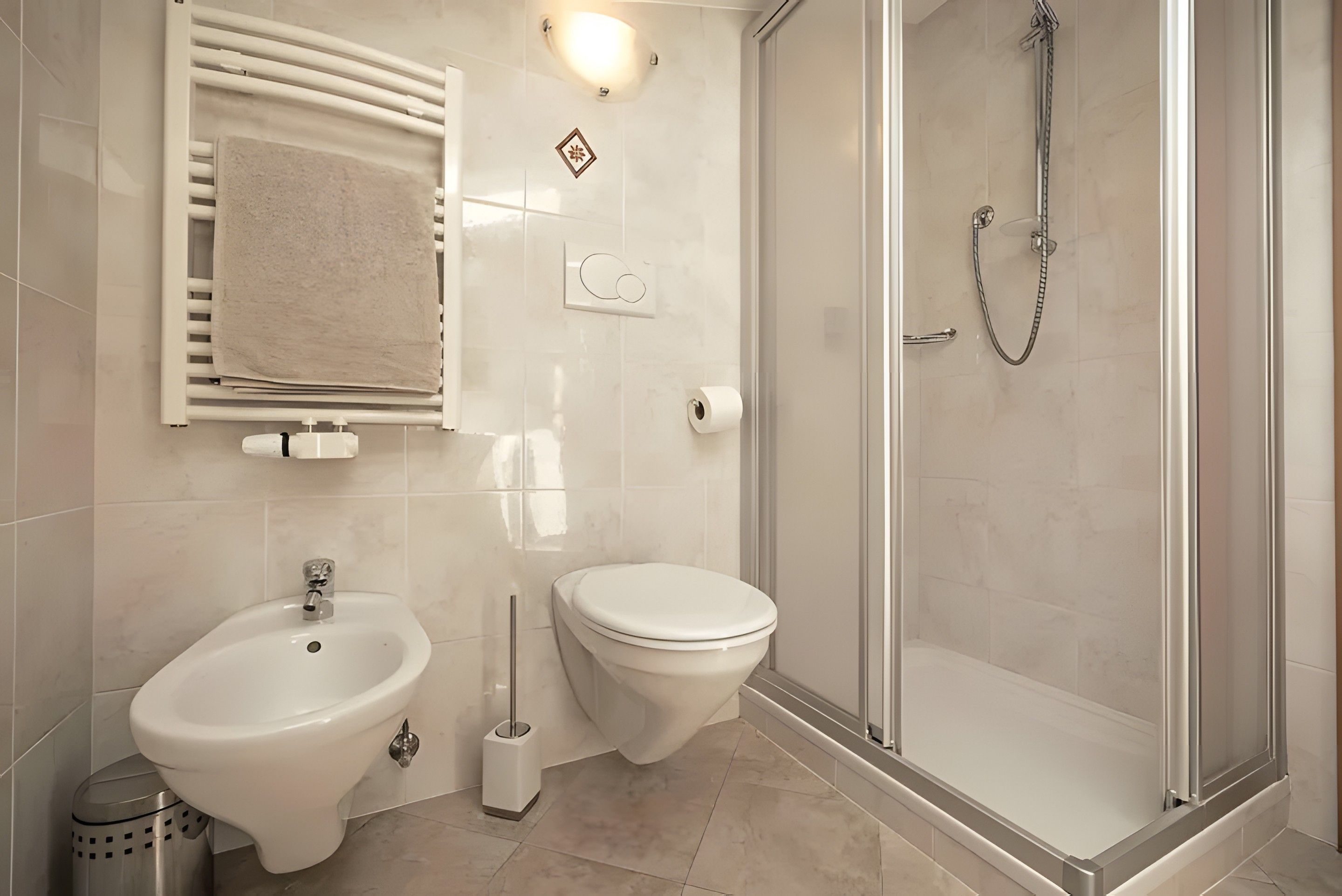 Ein Badezimmer mit Bidet, Toilette und einer Duschkabine.