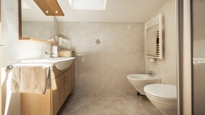 Un baño moderno con tragaluz, una bañera independiente, un inodoro y un lavabo.