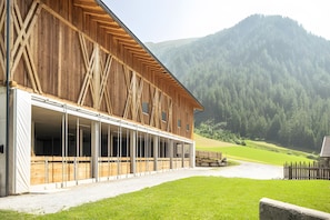 Un edifici de fusta gran amb un vestíbul cobert i vista a un paisatge de muntanya.
