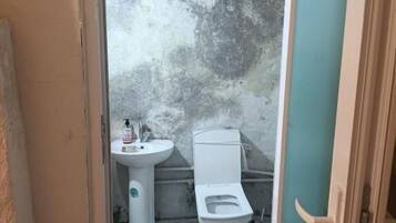 A bathroom with a toilet, sink, and marble flooring.