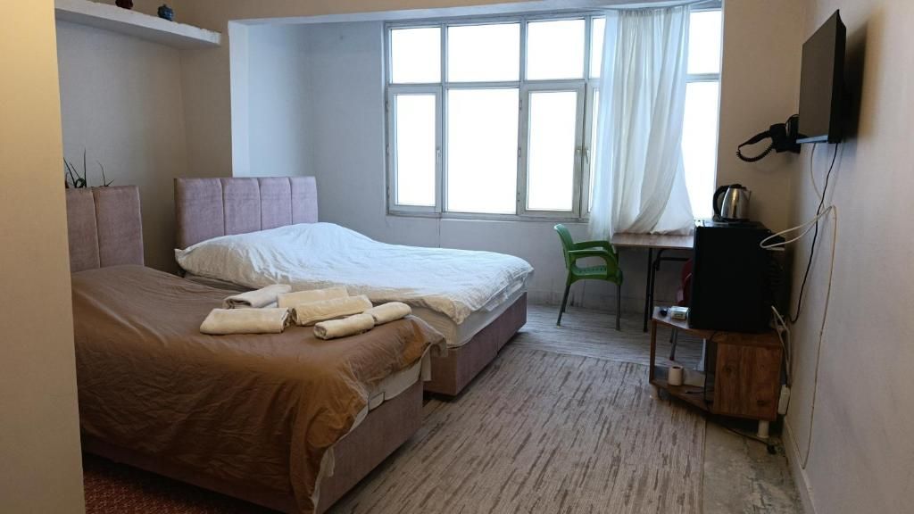 Ein Schlafzimmer mit einem Bett, einem Schreibtisch, einem Stuhl und einem Fernseher.