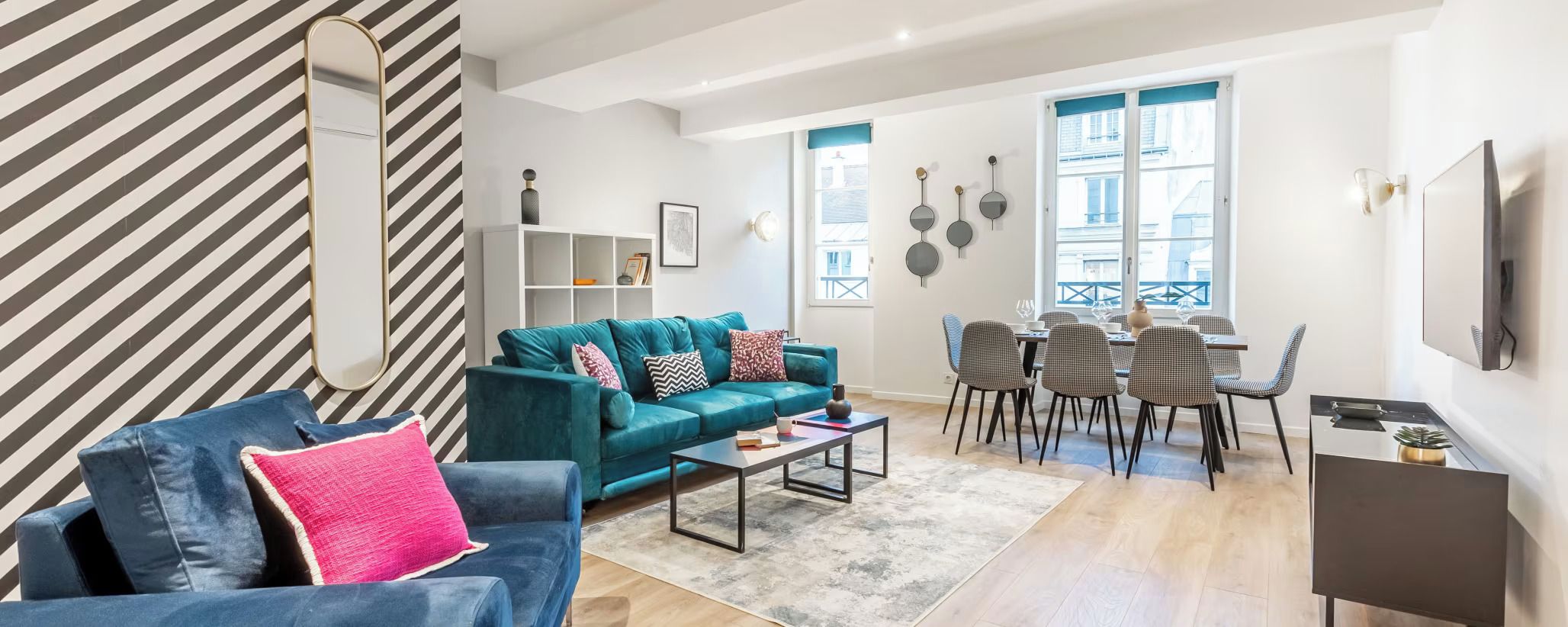 Una sala moderna con sofá, mesa de centro y comedor.