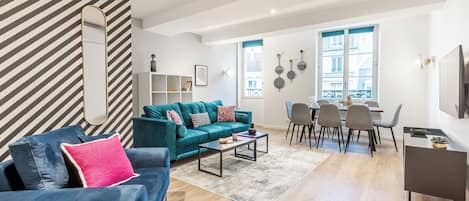 Una sala moderna con sofá, mesa de centro y comedor.
