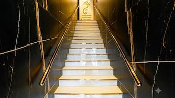 Un escalier muni d’une rampe et d’un panneau avec du texte en haut.