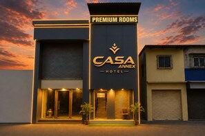 A hotel with a sign for 'CASA ANNEX HOTEL' and 'PREMIUM ROOMS' indicating a section for high-end accommodations.