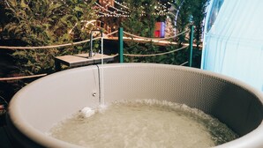 A hot tub with a rope barrier and a wooden platform.