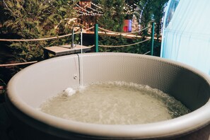 A hot tub with a rope barrier and a wooden platform. - Magas Bubble Houses (Dajt)