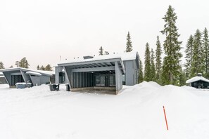 A snow-covered building with a covered entrance and a small adjacent structure.