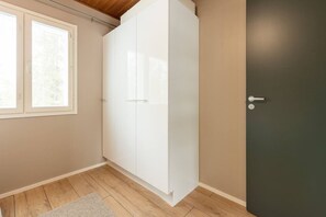 A room with a wardrobe, a door, and a window.