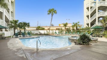 A swimming pool with lounge chairs and a palm tree.