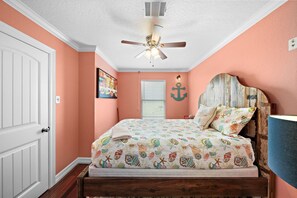 A bedroom with a bed, a ceiling fan, a door, and a wall with a picture. - Ranger Resort- Pool/Patio- Close to Beach (Galveston)