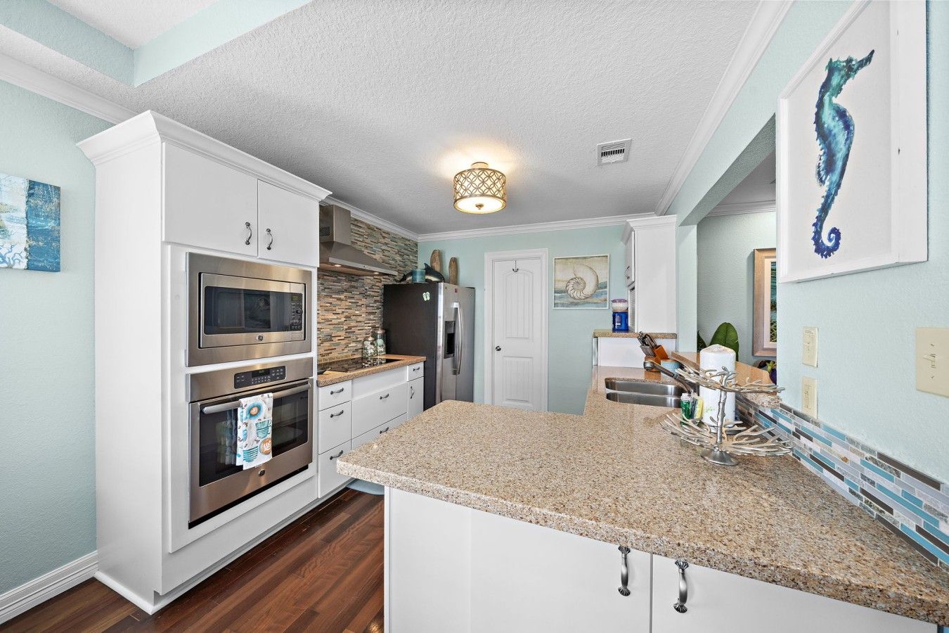 A modern kitchen with white cabinetry, stainless steel appliances, and a granite countertop.