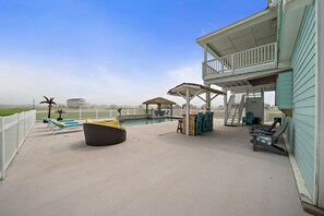 A covered outdoor area with a pool, lounge chairs, and a seating area. - Ranger Resort- Pool/Patio- Close to Beach (Galveston)