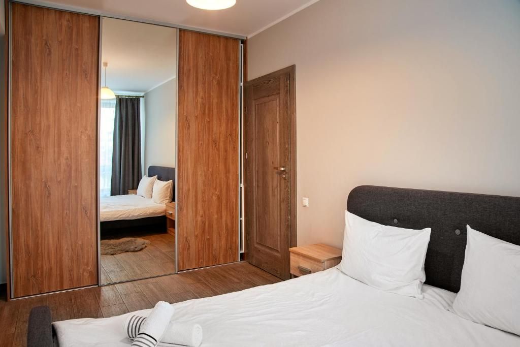 Une chambre à coucher avec un lit, une armoire en bois, une table de chevet et une porte.