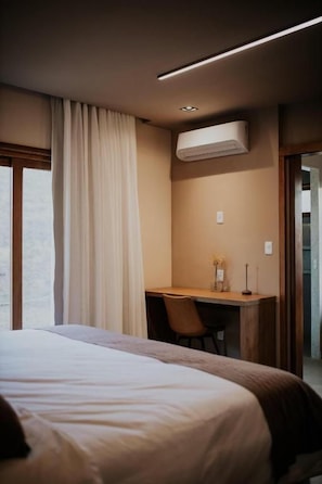 A hotel room with a bed, a desk, and an air conditioning unit. - Villa Arouca (Areal)