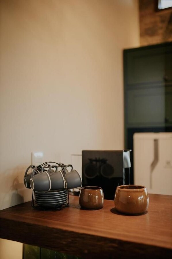 A wooden table with a tea kettle set and two mugs.