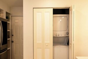 Une buanderie équipée d’un lave-linge et d’un sèche-linge, avec une porte et un four à micro-ondes.