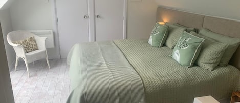 Une chambre à coucher avec un lit, une chaise et une armoire.