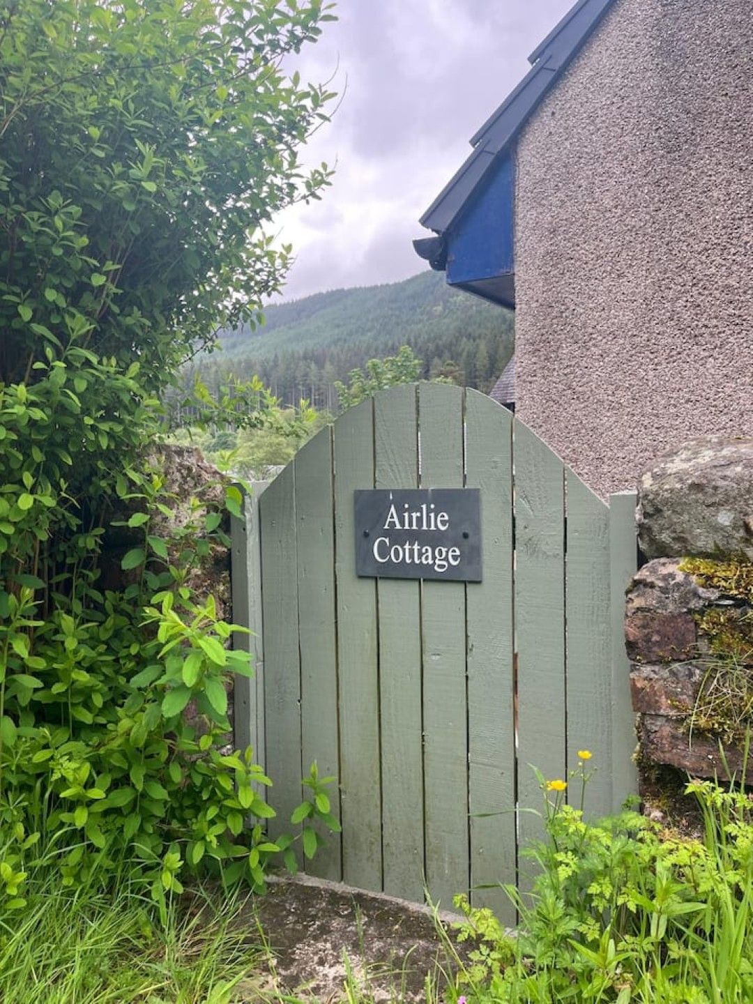 Una puerta de madera con un cartel que dice 'Airlie Cottage'.