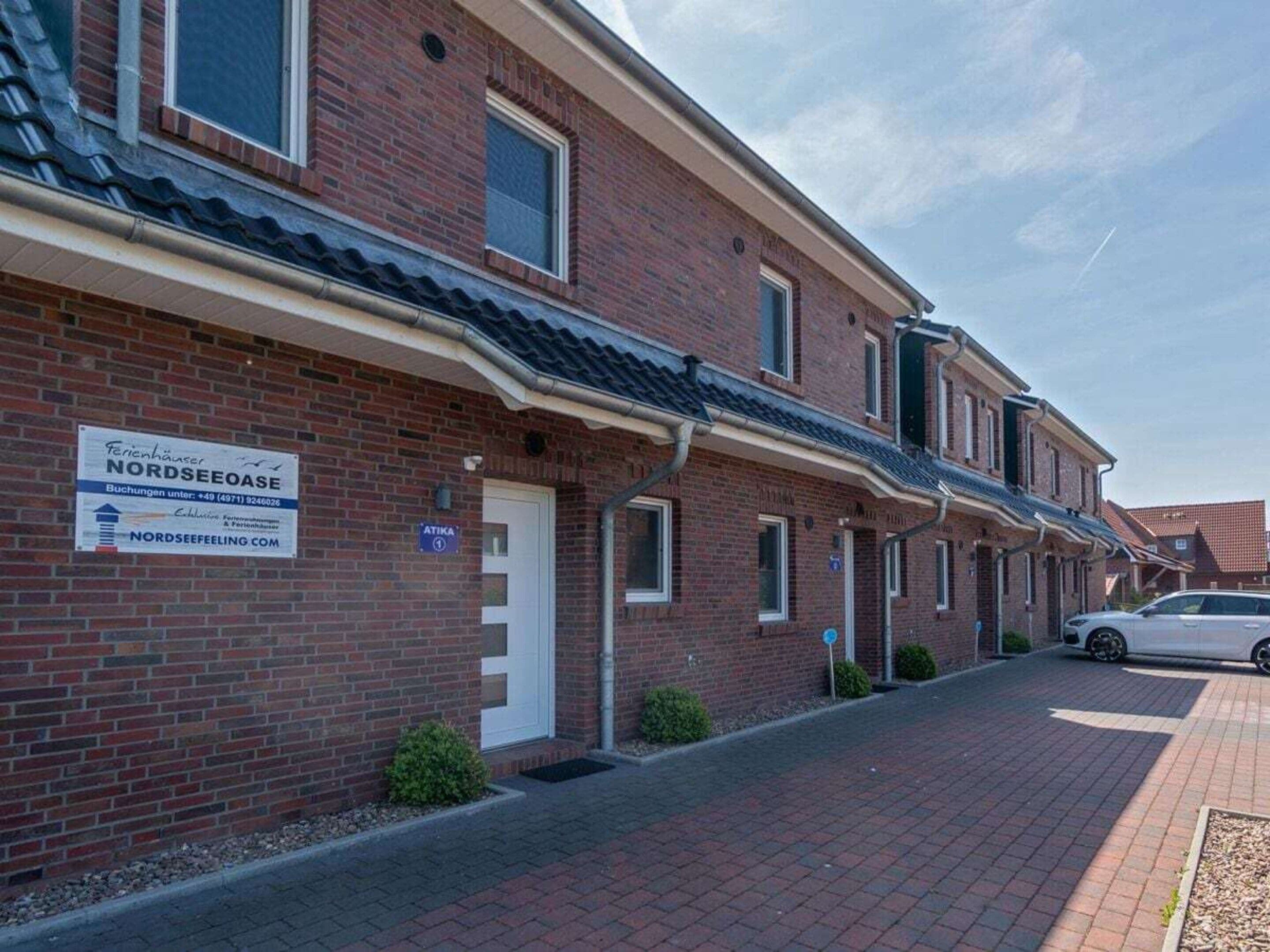 A row of brick buildings with a sign indicating a business named 'NORDSEEFEELING.COM'.