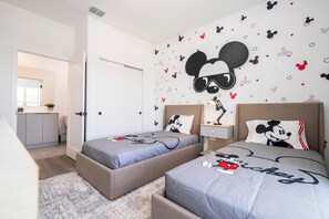A bedroom with two beds, each with Mickey Mouse-themed bedding. - Modern 4BR Home • Private Pool • Near Disney (Kissimmee)
