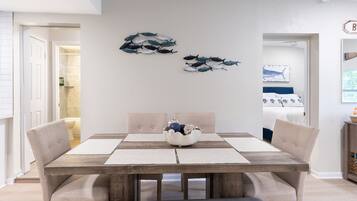 A dining area with a wooden table, cushioned chairs, and a decorative bowl.