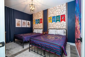 A bedroom with two beds, a stone wall, and a series of banners. - Doppio Westside home, 15min Disney, pool (Kissimmee)
