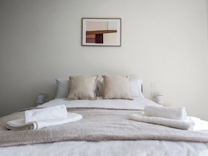 A neatly made bed with pillows and a blanket, a framed picture on the wall, and bedside lamps. - Luxury Flat - Sleeps 6 - Private Balcony - 10 Min to Wembley Stadium - WiFI (Harrow)