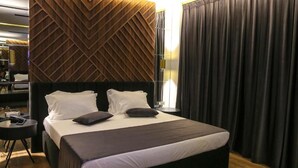 Une chambre d’hôtel avec un grand lit, un bureau et un décor mural moderne.
