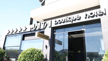 Un hotel boutique con un letrero de recepción y amplias ventanas.