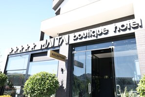 A boutique hotel with a reception sign and large windows.