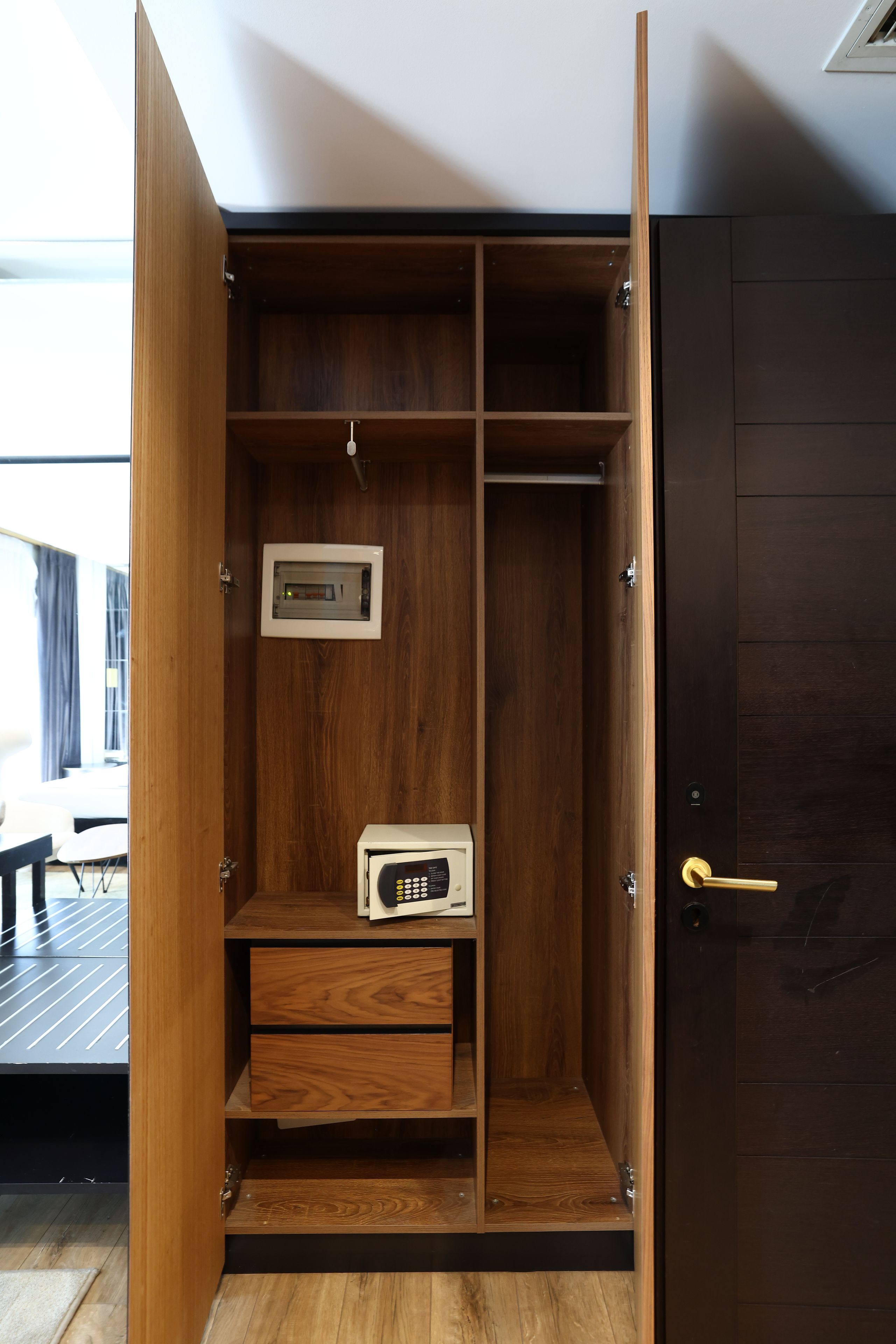 Un armario de madera con varios compartimentos, incluyendo un espacio para colgar ropa y un pequeño estante.