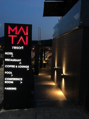 Señal para el resort MATAI con una lista de servicios que incluye hotel, restaurante, cafetería y salón, piscina, sala de conferencias y estacionamiento.