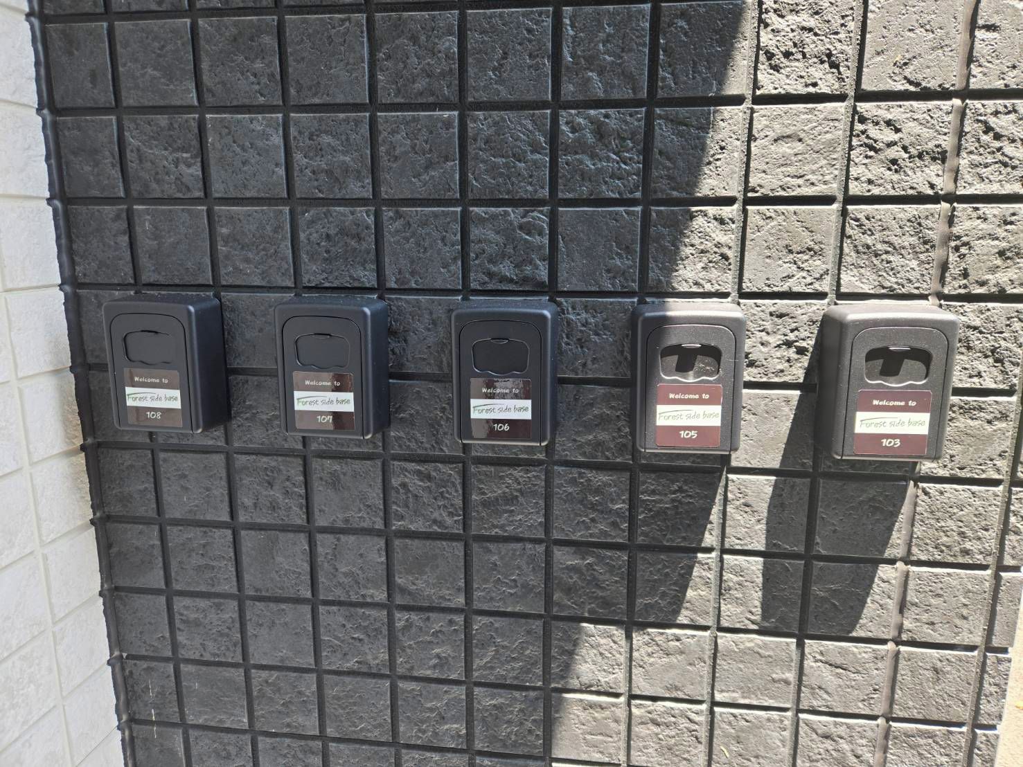 Un mur orné de quatre appareils noirs de forme carrée, chacun étant muni d’une étiquette et d’un numéro.