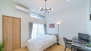 Ein modernes Schlafzimmer mit Bett, Schreibtisch und Computer.
