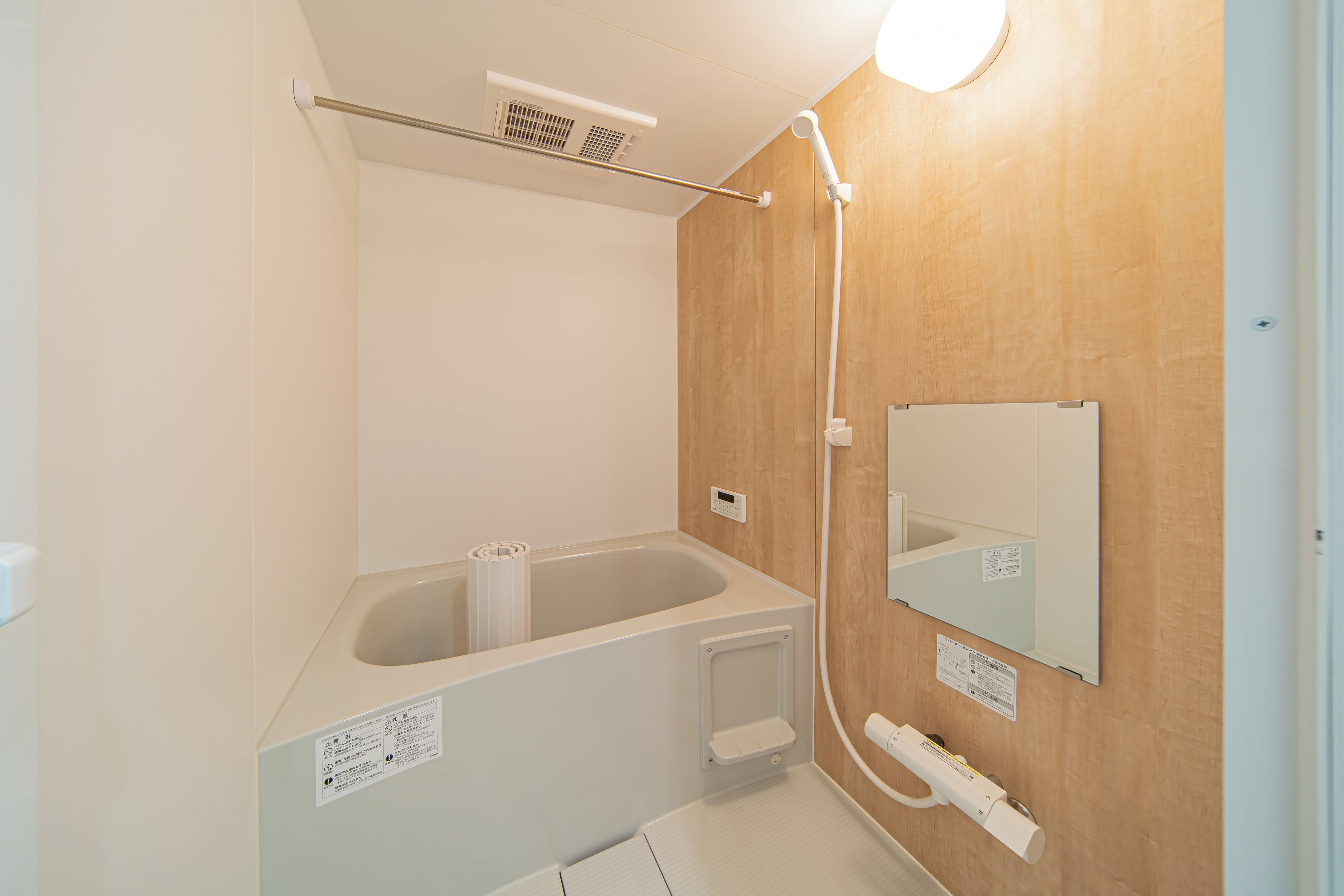 A bathroom with a bathtub, a shower, and a mirror.
