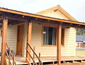 A wooden cabin with a porch, a door, and a window. - Don Edmundo Trevelin (Trevelin)