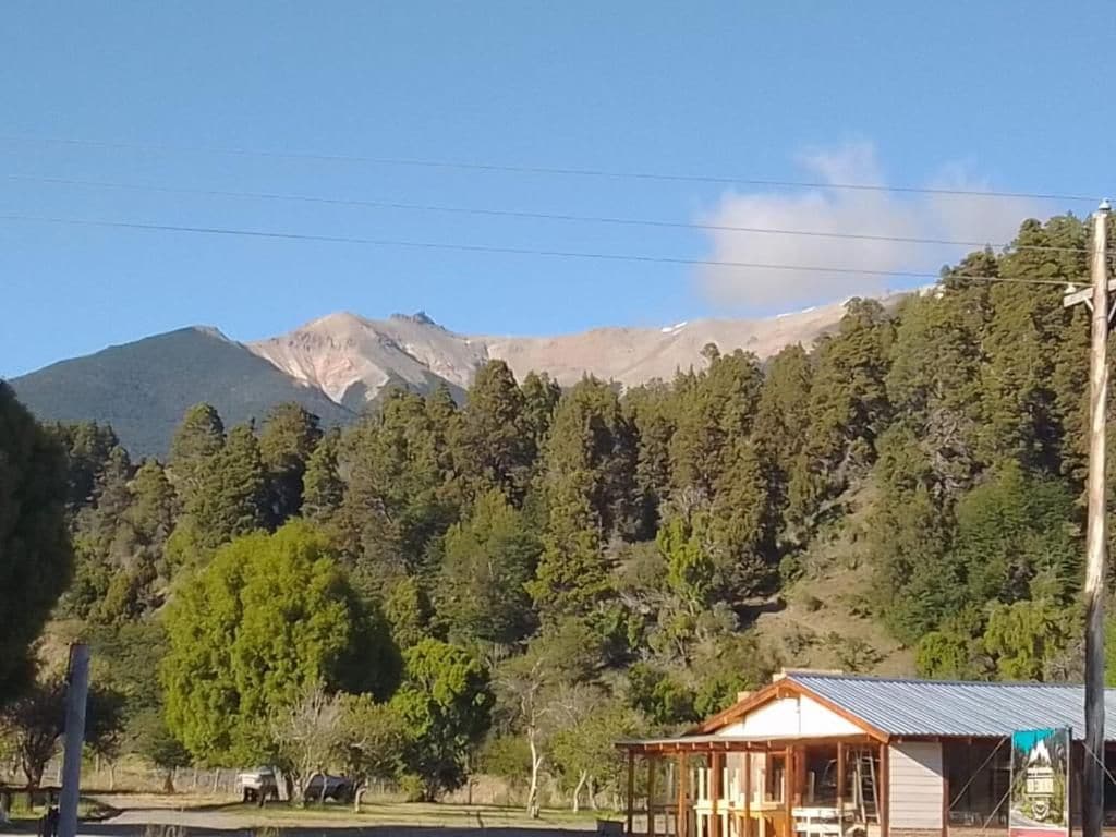 A mountain landscape with a wooden cabin structure.