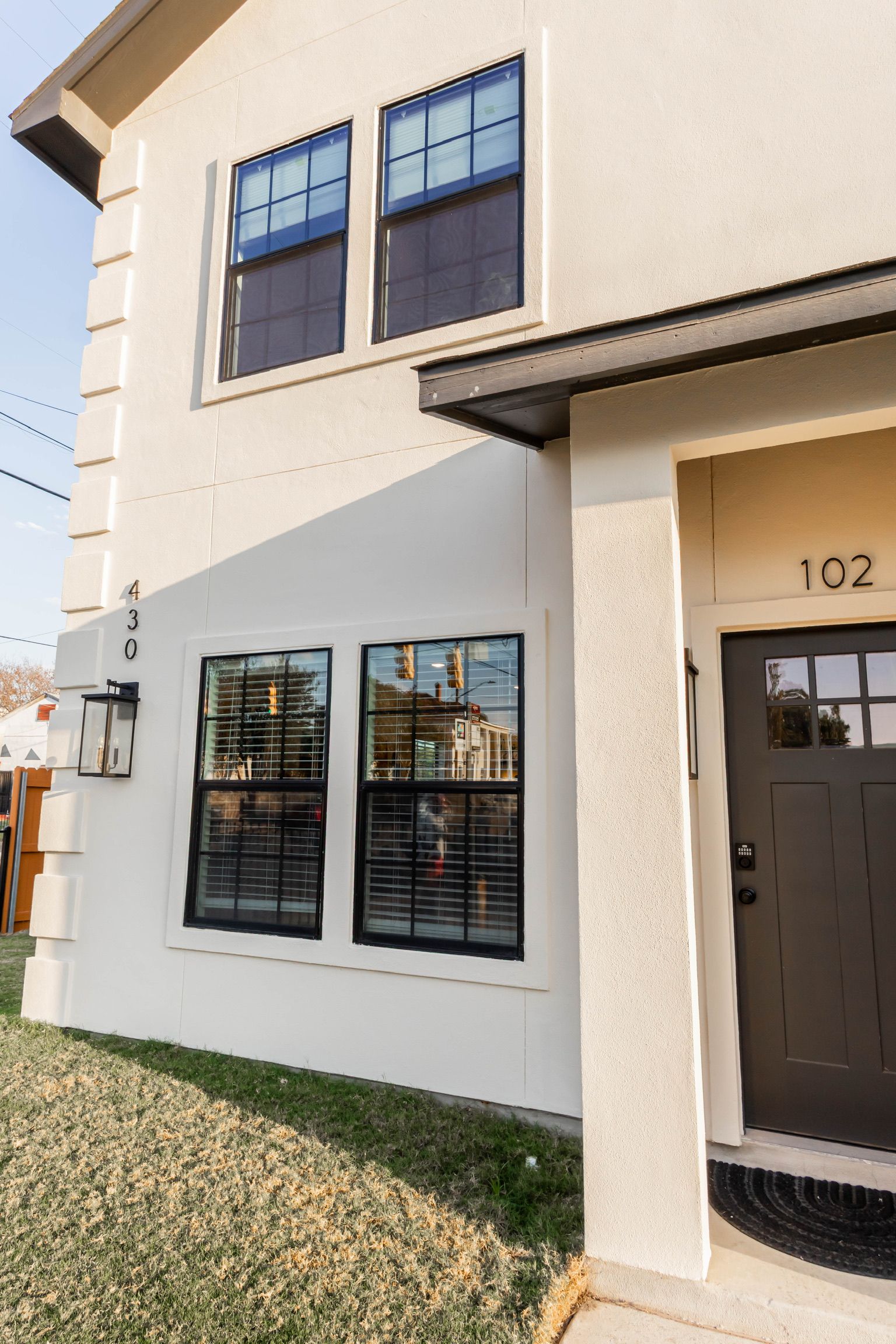 A two-story building with a flat facade, large windows, and a dark front door.